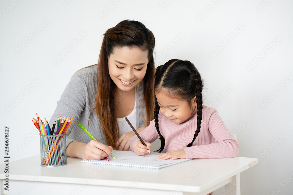 Asian moms are teaching crayon skills to Daughters. To draw a line. Write book on paper Artistic development Imagine And the mood of the children very well. And the family is very understanding love. Asian moms are teaching crayon skills to Daughters. To draw a line. Write book on paper Artistic development Imagine And the mood of the children very well. And the family is very understanding love.