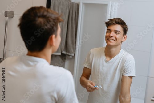 morning routine. man brushing teeth in bathroom