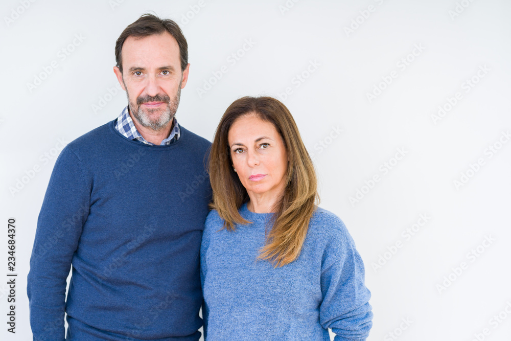 Beautiful middle age couple in love over isolated background Relaxed with serious expression on face. Simple and natural looking at the camera.