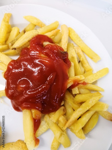 Pommes Frites Nahaufnahme Detail mit Ketchup auf weißem Hintergrund photo