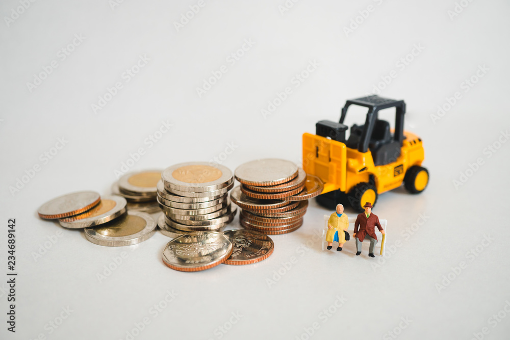 Fototapeta premium Miniature elderly people sitting with stack coins and folklift truck using as business and industrial concept