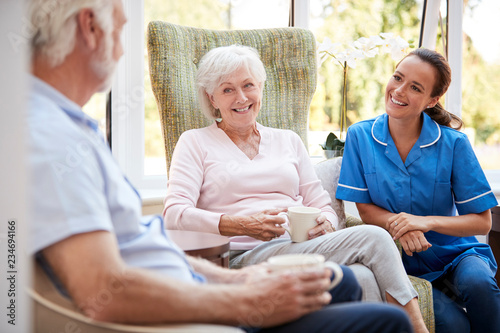 Canvastavla Senior Couple Sitting In Chair And Talking With Nurse In Retirement Home
