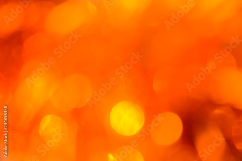 Bokeh. Holiday background. Christmas lights. Glitter. Defocused sparkles. New Year backdrop. Festive wallpaper. Blinks. Carnival. Bokeh retro style photo. Orange.