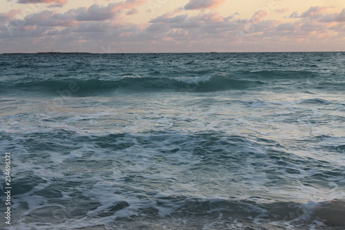 The Atlantic Ocean. off the coast of Cuba  early morning. light cloud cover  pink sky.