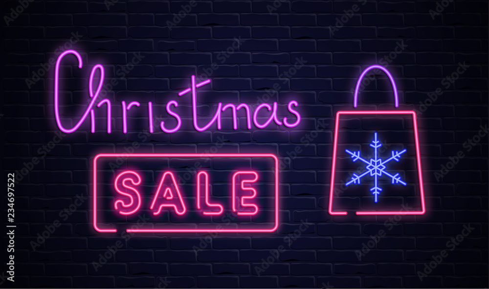 Christmas sale pink neon promo poster with shopping bag on brick textured background.