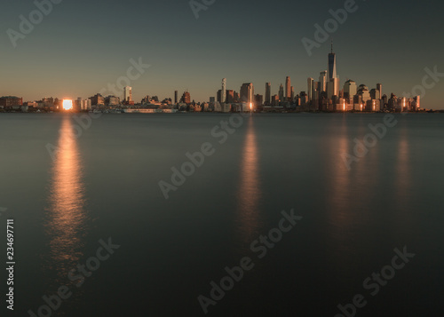 View on fiance district in Manhattan from Hudson river at sunset with sun reflection 