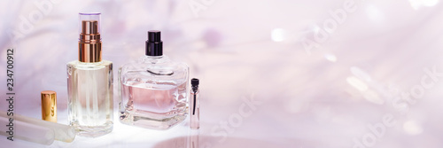 Canvas Print Different perfume bottles and sampler on a pink floral background