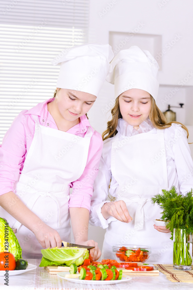 Portrait of two cute girls cooking on kitchen Portrait of two cute girls cooking on kitchen
