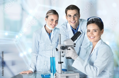 Female and male scientists in glasses working with microscope