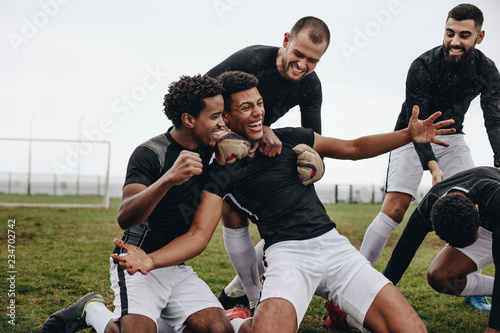 Fototapeta Naklejka Na Ścianę i Meble -  Soccer players doing a knee slide after scoring a goal