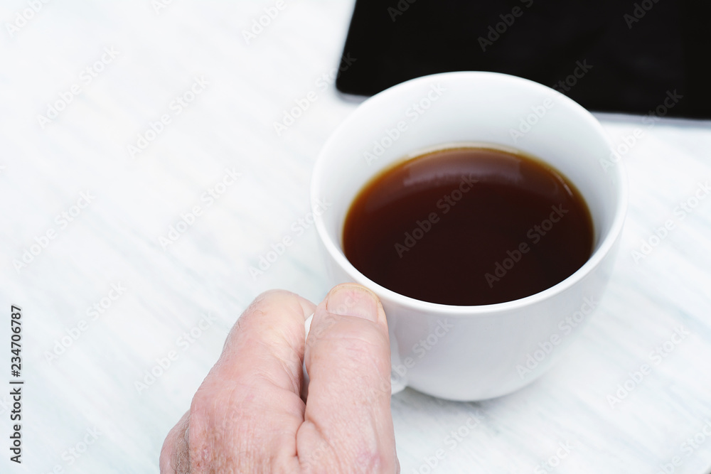 Close up of senior man holding cup of coffee Close up of senior man holding cup of coffee