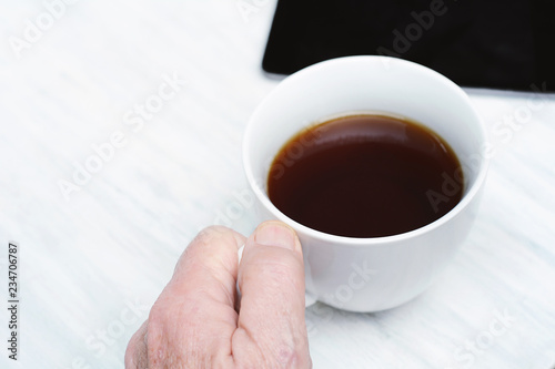 Close up of senior man holding cup of coffee