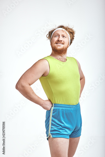 Red haired, bearded, plump man is proud to wearing sportswear
