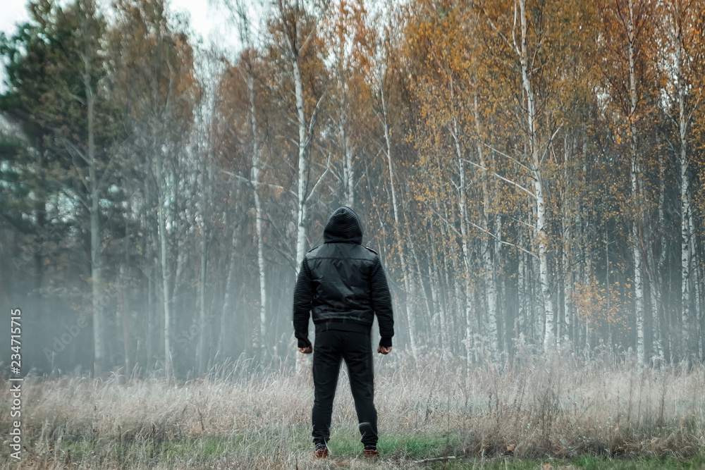 Creative background, Man, man in a black coat in foggy weather, against the background of the forest. The concept of mysticism, autumn, cold, ghost, shepherd. Creative background, Man, man in a black coat in foggy weather, against the background of the forest. The concept of mysticism, autumn, cold, ghost, shepherd.