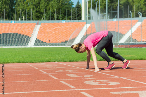 A young girl in the stadium is preparing to start.