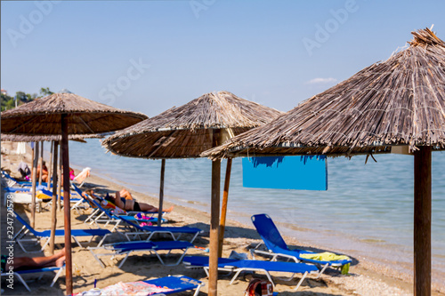 Colored empty wooden sign hang under thatched sunshade