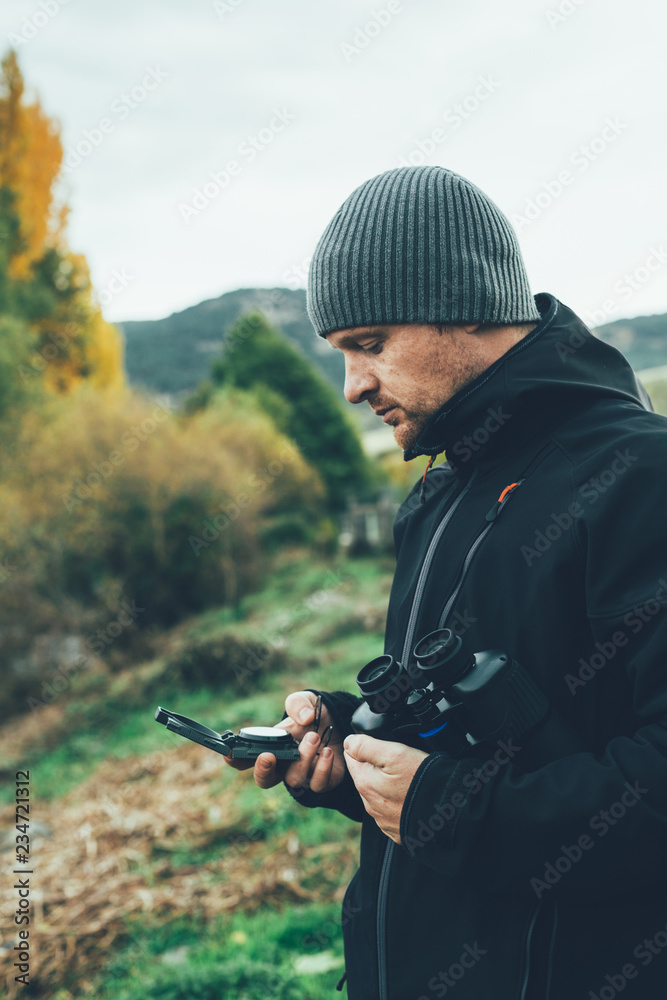 A young man with binoculars in te mountain A young man with binoculars in te mountain