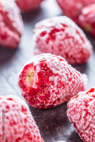 Close-up frozen strawberries covered by frost.