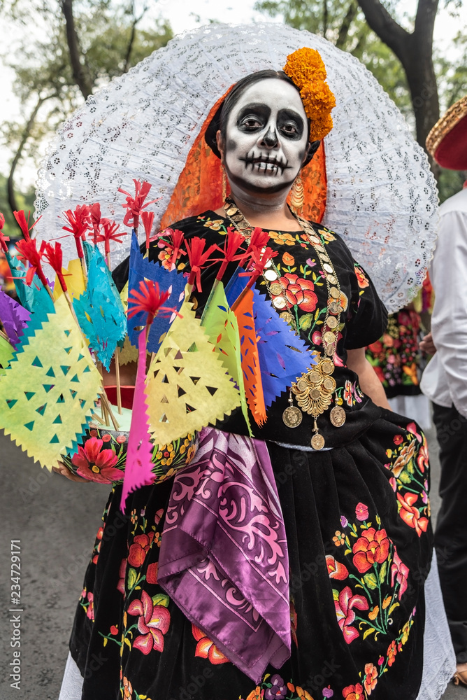 Colorful participants in the festival of the Day of the dead in Mexico. Attractive skull costumes worn by dancing Mexican girls