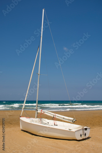 Sailboat on beach sand with sea on background