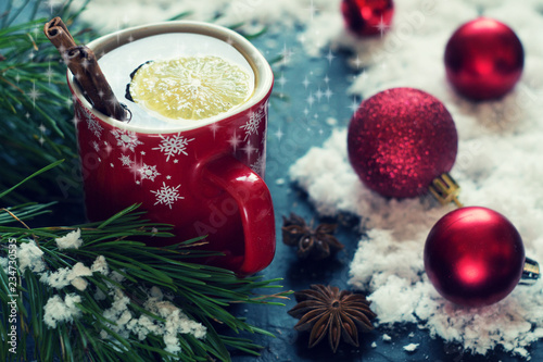 Tea with lemon near the Christmas tree and red balls