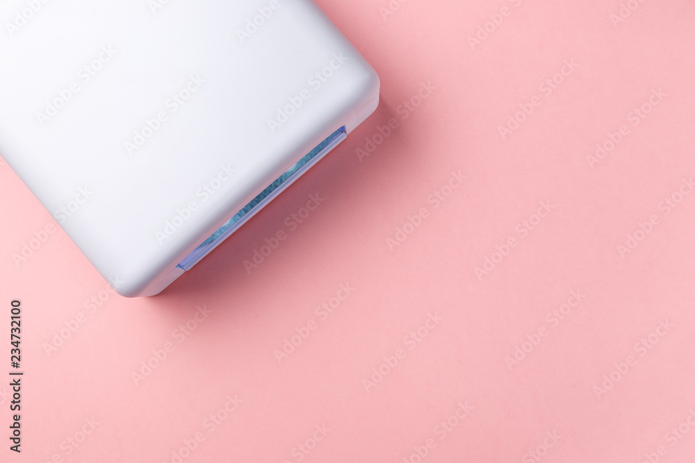 UV lamp lights for nails on pink background. Top view. Flat lay. Copy space. Minimal creative concept. Pink background in pastel colours UV lamp lights for nails on pink background. Top view. Flat lay. Copy space. Minimal creative concept. Pink background in pastel colours