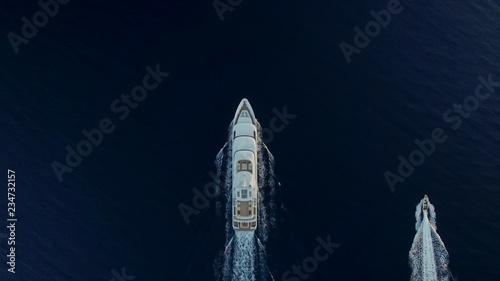 Top-down view of large luxury yacht and small boat