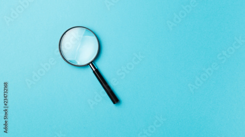 Magnifying glass on pastel background. Top view. Flat lay. Copy space. Minimal creative concept. Blue background in pastel colours