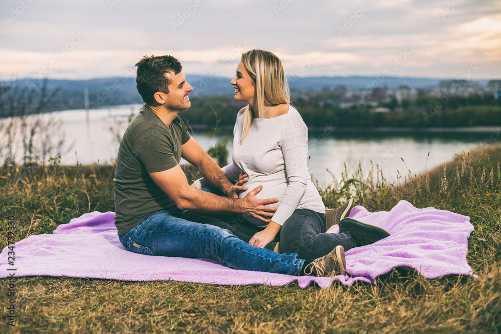 Husband and  pregnant wife  enjoy spending time together outdoor.