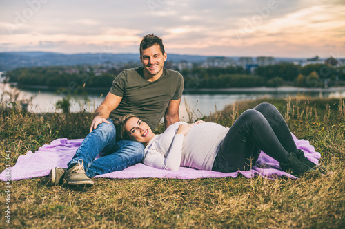 Husband and his pregnant wife enjoy spending time together outdoor. © inesbazdar