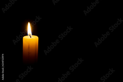 burning wax candle on a black background photo