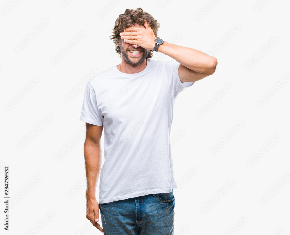Handsome hispanic model man over isolated background smiling and laughing with hand on face covering eyes for surprise. Blind concept. Handsome hispanic model man over isolated background smiling and laughing with hand on face covering eyes for surprise. Blind concept.