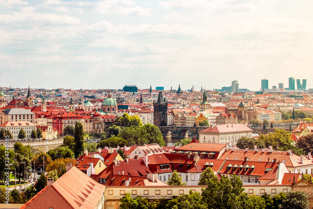 Obraz premium Prague, Bohemia, Czech Republic. Scenic view of bridges on the Vltava river and of the historical center of Prague : Old town bridge tower and landmarks of old town with red rooftops and houses.