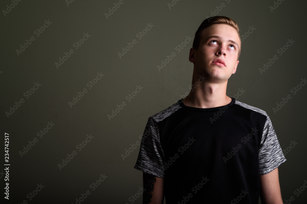 Obraz premium Young handsome man with blond hair against colored background
