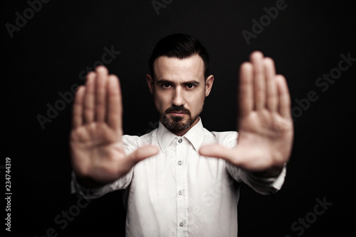 Handsome man makes stop gesture. © dinachi