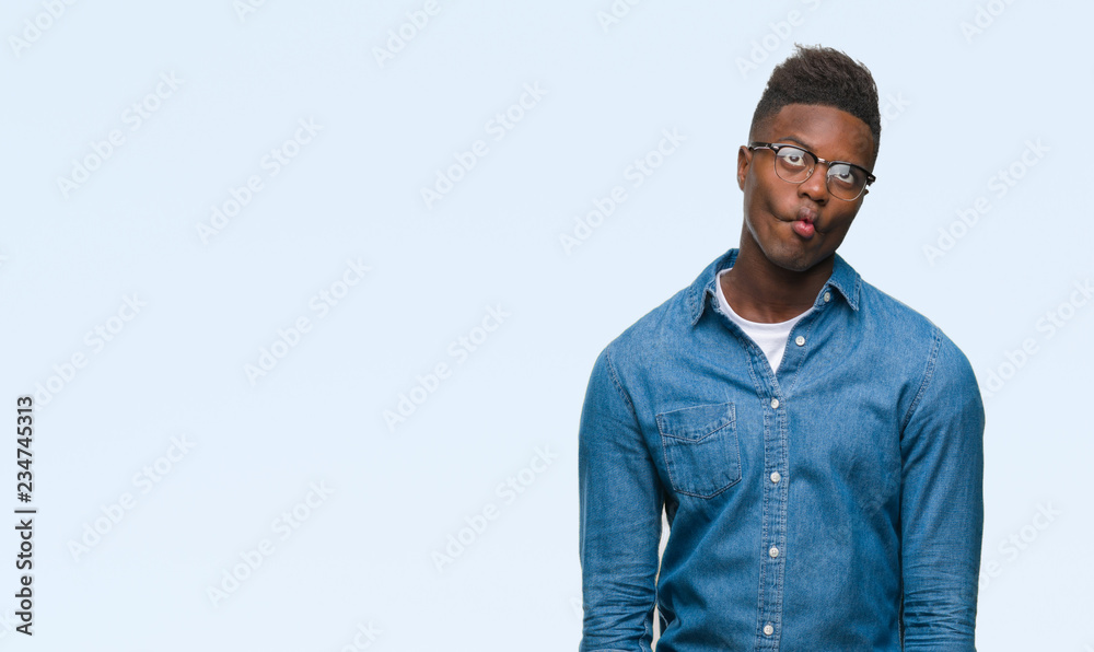 Fototapeta premium Young african american man over isolated background making fish face with lips, crazy and comical gesture. Funny expression.