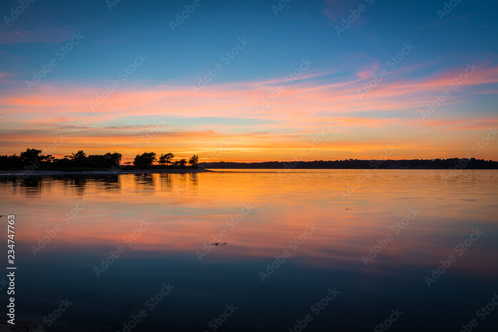 Beautiful sunset over bay with reflections