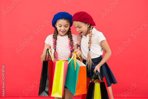 Children enjoy shopping red background. Visiting clothing mall. Discount and sale concept. Kids cute girls hold shopping bags. Shopping discount season. Special offer. Great day for shopping