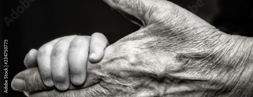 Childs hand and old wrinkled skin palm finger Concept idea of love family protecting children and elderly people grandparent friendship togetherness relationship Two generation Black and white. photo