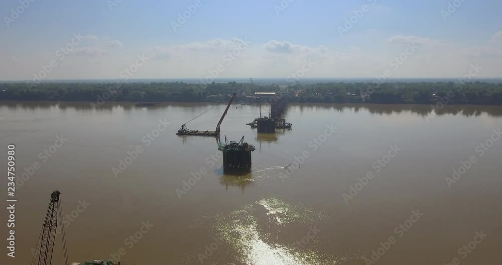 aerial drone shot : fly towards bridges foundations and barges mounted cranes in river aerial drone shot : fly towards bridges foundations and barges mounted cranes in river
