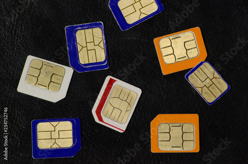 Many cellphone sim cards in different formats for black Background