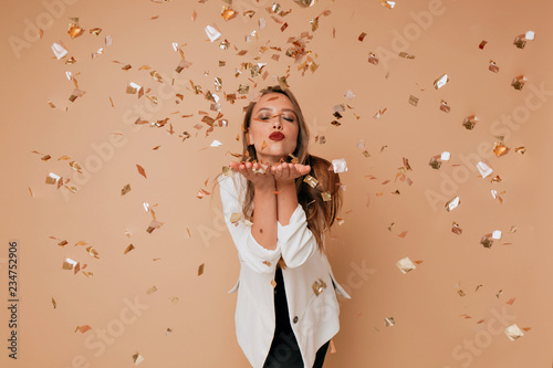 Portrait of happy lovely woman send a kiss to camera on isolated background with confetti. Happy celebration of new year, birthday