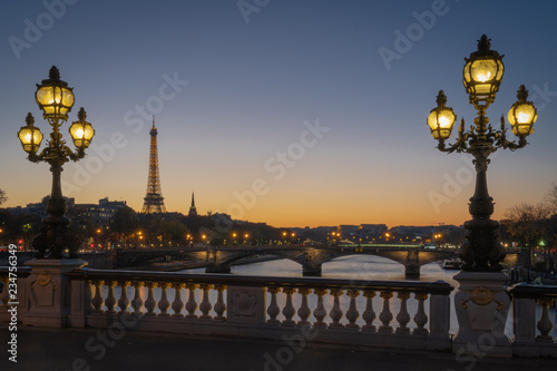 Paris, France - 11 18 2018: panoramic view of Paris and the Eiffel Tower from the Alexander III bridge with floor lamp at sunset