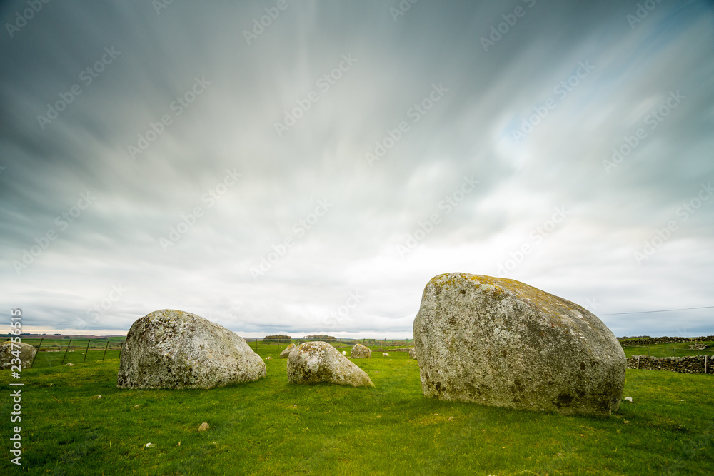 A long exposure photograph of Torhouse Stone Circle, Newton Stewart, Dumfries and Galloway, Southern Scotland under heavy and dramatic skies
