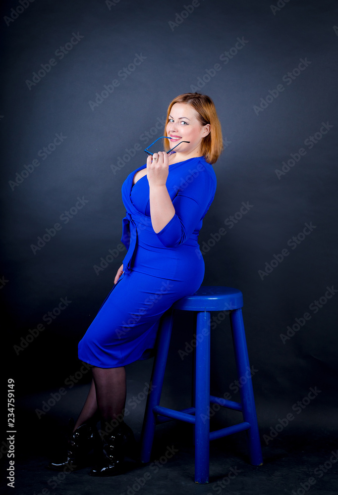 Beautiful chubby girl in blue elegant dress on a black background. Sexy ...