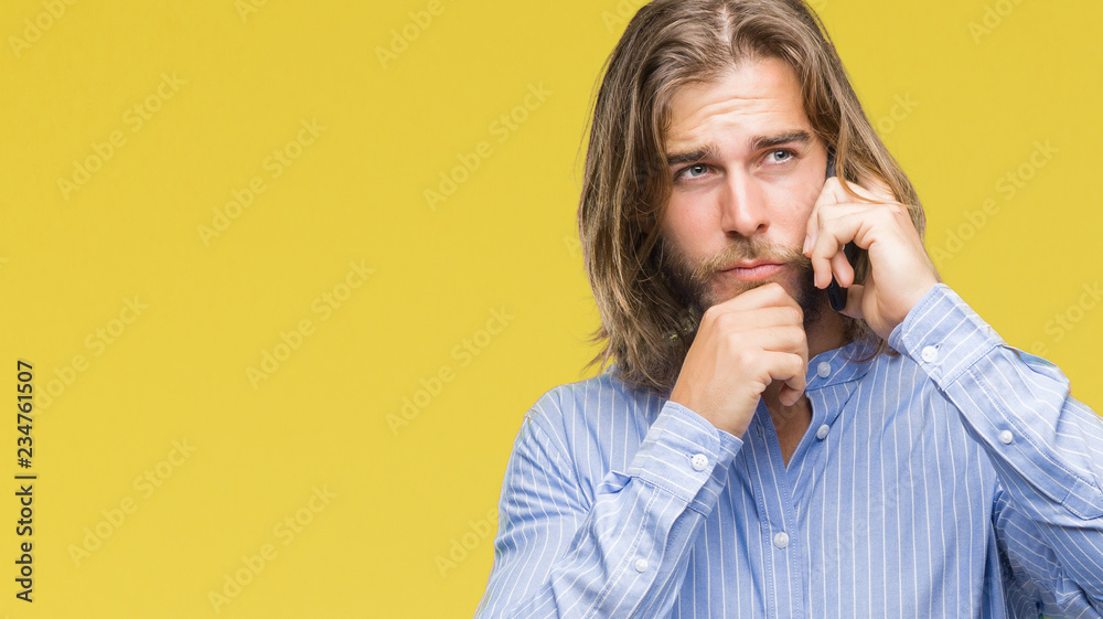Young handsome man with long hair over isolated background talking on the phone serious face thinking about question, very confused idea Young handsome man with long hair over isolated background talking on the phone serious face thinking about question, very confused idea