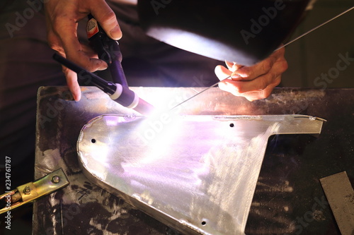 worker tig welding metal