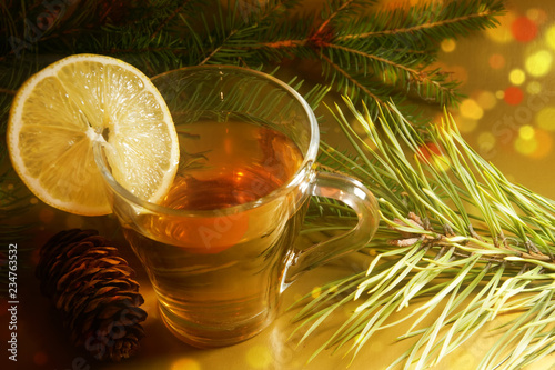 hot tea with a slice of lemon on new year's eve spruce and pine branches