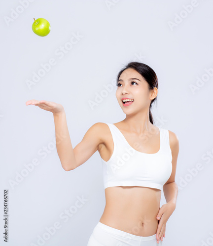 Portrait asian woman smiling throw green apple fruit and beautiful body diet with fit isolated on white background, girl weight slim with cellulite or calories, health and wellness concept.