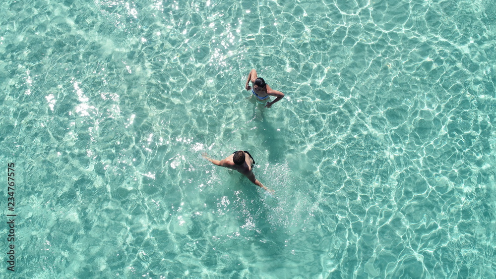 Couple in crystal clear water from the Air.